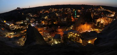 Geceleri Kapadokya'nın Göreme kentinin panoramik manzarası. Ünlü peri bacaları etrafında inşa edilen şehir, Türkiye'nin popüler seyahat destinasyonu.