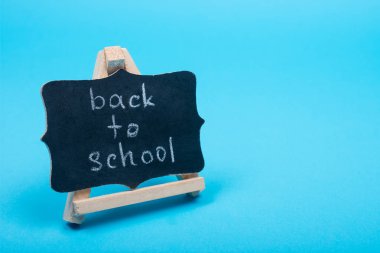 Geri okul kelime üzerinde mavi bir arka plan kopya alanı (olarak geri okul kavramı için sağdaki küçük yazı tahtası)