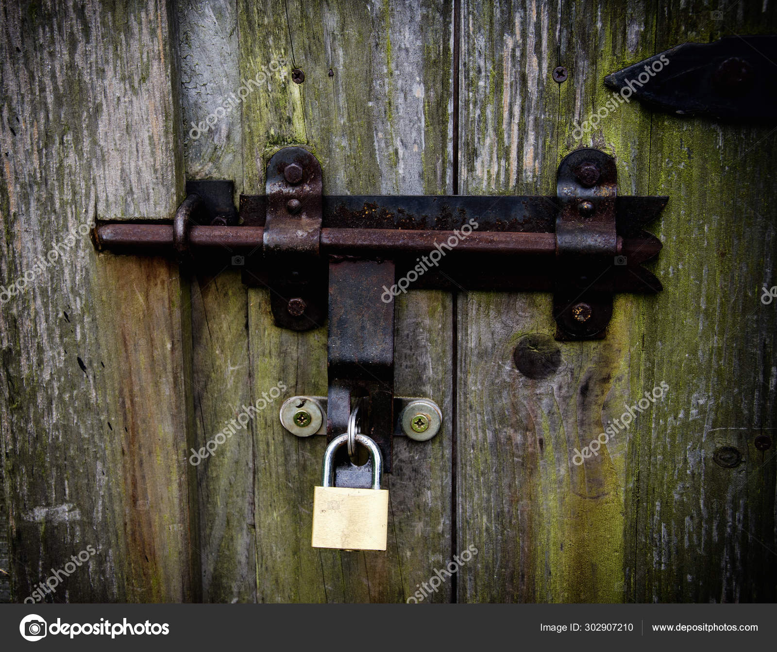 Old Locked Wooden Door With An Iron Lock Stock Photo