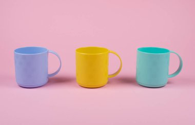 Üst üste mavi, sarı ve yeşil bardaklar