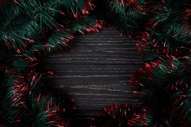 Siyah ahşap arka plan üzerinde yeşil ve kırmızı tinsel