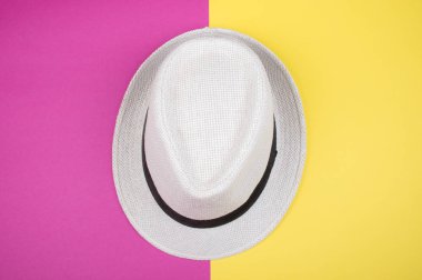 Parlak pembe ve sarı arka planda beyaz şapka