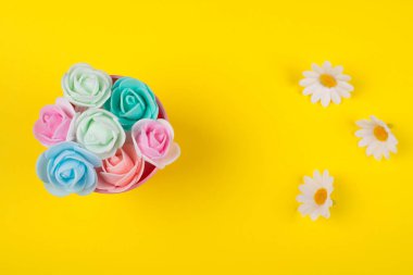 Bir kova ve papatya çiçekleri el yapımı gül tomurcukları