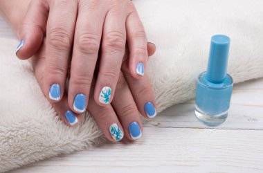 Eller beyaz bir havlu ve bir şişe oje