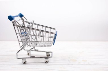 Beyaz ahşap arka plan üzerinde alışveriş sepeti