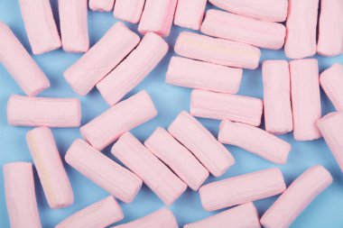 Pastel mavi arka plan üzerine pastel pembe marshmallow