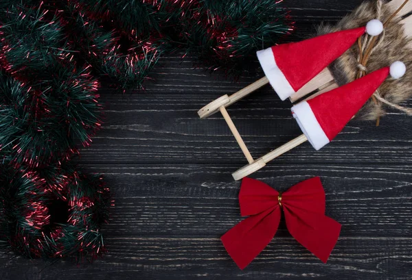 Chapéus de Papai Noel em um trenó de Natal e um arco de Natal — Fotografia de Stock