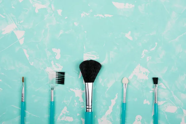 Conjunto de pincéis de maquiagem em um fundo de mármore azul — Fotografia de Stock