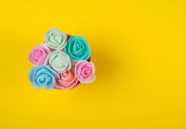 Brotes de rosa hechos a mano multicolores sobre un fondo amarillo — Foto de Stock