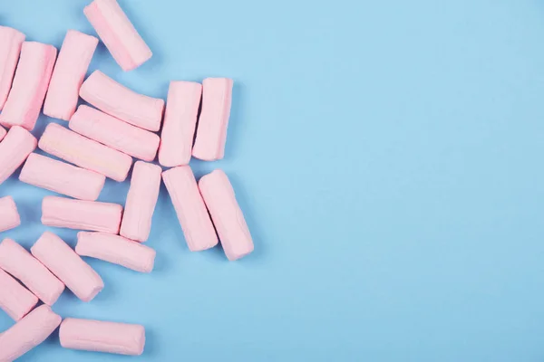 Pastel marshmallows rosa em um fundo azul pastel — Fotografia de Stock
