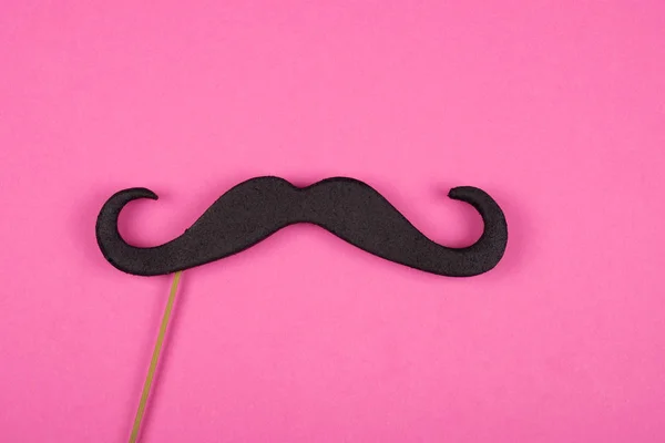 Moustache em um pau contra um fundo rosa — Fotografia de Stock