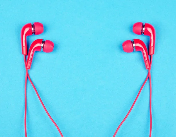 Pairs of bright red earbud headphones — Stock Photo, Image