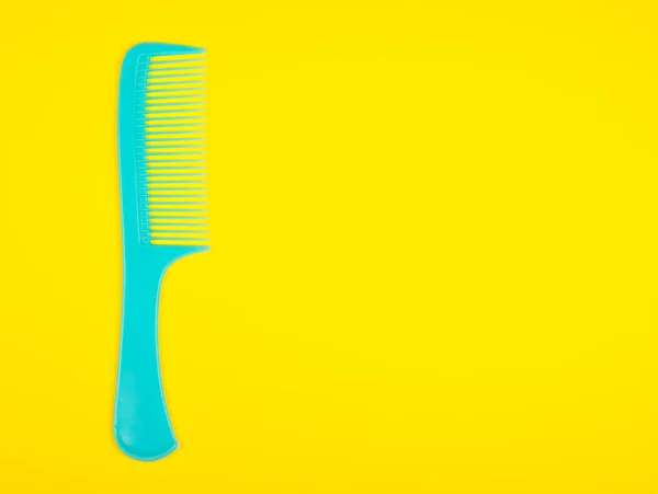 Blue hair comb on a bright yellow background — Stock Photo, Image