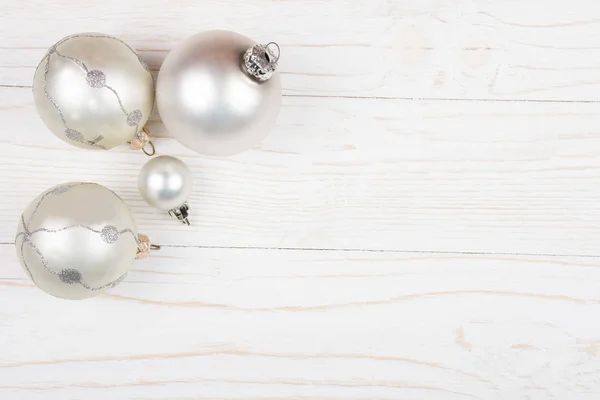 Christmas balls of a silver color on a wooden background