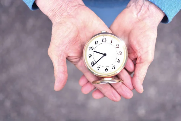 老妇人手里拿着一个闹钟 老祖母的手 时间观念不静止 — 图库照片