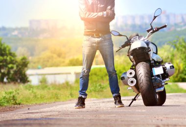 Motosikletçi onun motosiklet açık havada duruyor