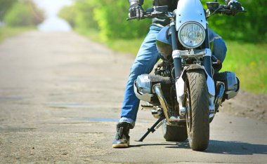 Motorcu şık kıyafeti motosikletine oturur. Bir motosiklet üzerinde motosikletçi aittir. 