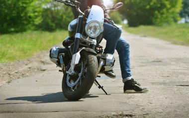 Motorcu durdurur ve onun motosiklet üzerinde oturur. Motosikletçi motosiklet aittir.