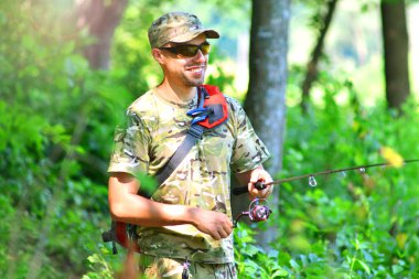 Mutlu balıkçı ve iplik bobin ile. Nehir Balık tutma arka plan. 