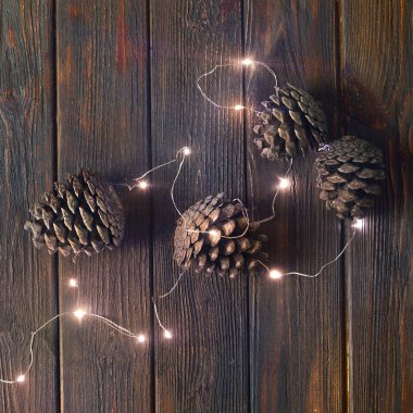 Güzel kış Noel arka plan kopya alanı ile ahşap dokulu arka plan üzerinde garland ve çam kozalakları ile kare