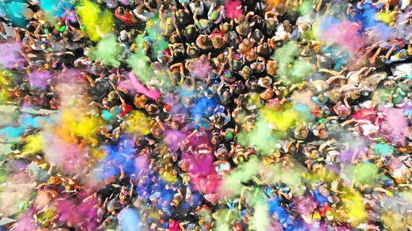ホーリー色祭の空中の平面図です 上記の人々 の群衆の中に塗料のスプラッシュを表示します — ストック写真