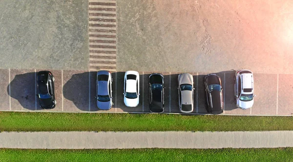 Parking lot with cars near the sidewalk. Aerial.