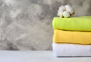 Doğal pamuk çiçek renkli pamuk havlu yığını. Banyo iç dekoratif sıva arka plan ile. Kopya alanı.