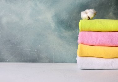 Doğal pamuk çiçek renkli pamuk havlu yığını. Banyo iç dekoratif sıva arka plan ile. Kopya alanı.