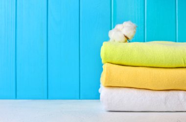 Doğal pamuk çiçek renkli pamuk havlu yığını. Bir mavi ahşap duvar ile rahat banyo iç. Kopya alanı.