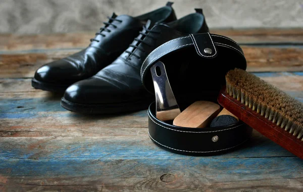 Shoes care concept with brush for footwear, shoes, accessories on a wooden background