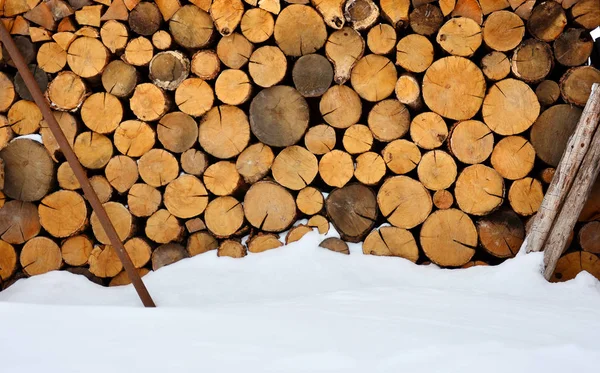 雪堆附近的冬季柴堆 质朴的背景 — 图库照片
