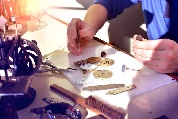 Watchmaker at work in workshop. Workplace of watch repairer. Process of repair mechanical watches