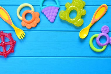 Bebek aksesuar arka plan çatal, kaşık ve teethers. Kopya alanı.