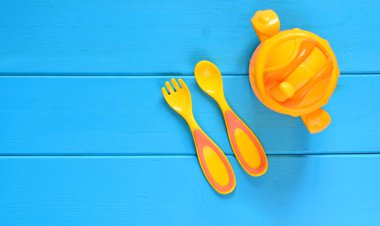 Bebek beslenme kavramı arka plan. Çocuk çatal, kaşık ve ahşap bir masa bardağa geçișin. 