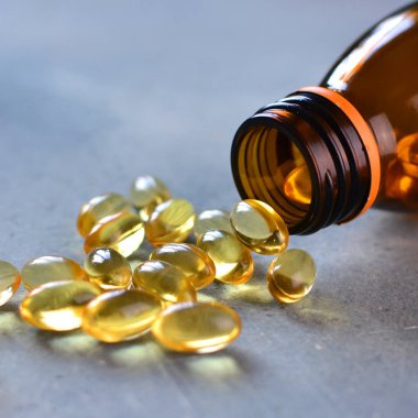 Omega 3 vitamin hapları şişeden dağınık, kırpılmış