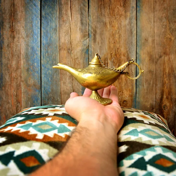 Lamp of wishes in a hand. Aladin lamp.