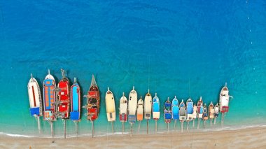 Denizde tekneler, en iyi manzara. Masmavi sularda Akdeniz kıyılarında yan yana duran renkli teknelerin havadan görünümü. Deniz arka plan ve yaz seyahat konsepti. 