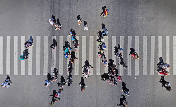 Aerial. People crowd on pedestrian crosswalk. Top view.