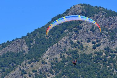 Yamaç paraşütü. Mavi gökyüzü ve dağlar arka planda Paragliders. 