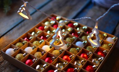 Ahşap rustik bir masada elektrikli çelenk ve xmas topları ile Noel arka plan