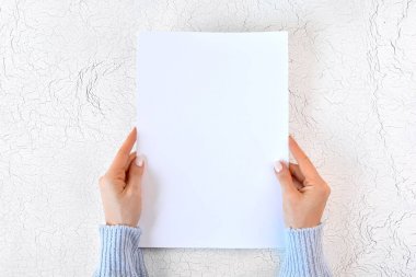 Tasarımınız veya mesajınız için kadın elinde boş beyaz kağıt levha