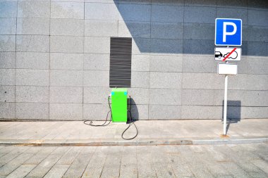 Bir şehir manzarasında elektrikli bir araba şarj etmek için Istasyon