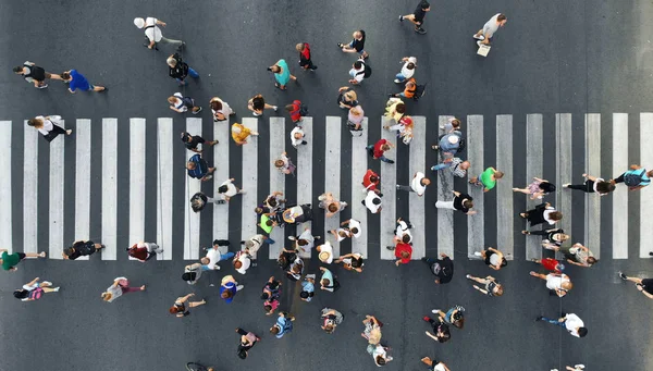 People crowd moving through the pedestrian crosswalk. Top view from drone.