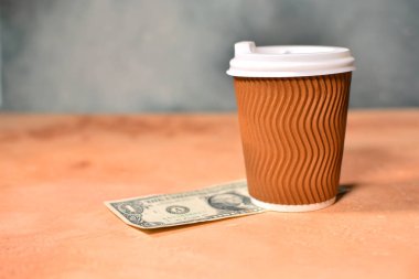 Bir fincan kahve ve bir masada bir Amerikan doları ile nakit ipucu kavramı