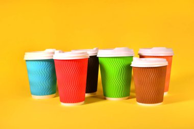 Sarı arka planda renkli kahve fincanları