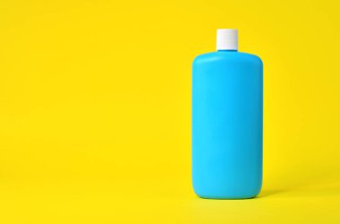 Sarı arka planda boş mavi plastik şişe