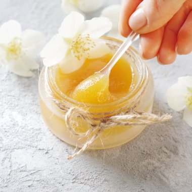 Tatlım, kozmetik cilt bakımı için doğal bir malzemedir. Taze altın bal yüz tedavileri için mükemmel bir organik üründür. Kadın özel bir kozmetik kaşıkla bal topluyor.. 