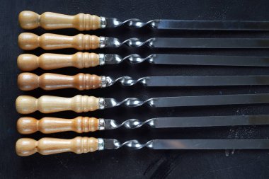 Masanın üzerinde ahşap saplı şişler, üst manzara.