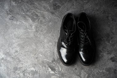 Beton zeminde duran şık uniseks siyah ayakkabılar. Üst Manzara. Boşluğu kopyala. 