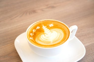 Sıcak, lezzetli bir kahveyle kaplanmış beyaz bir fincan.